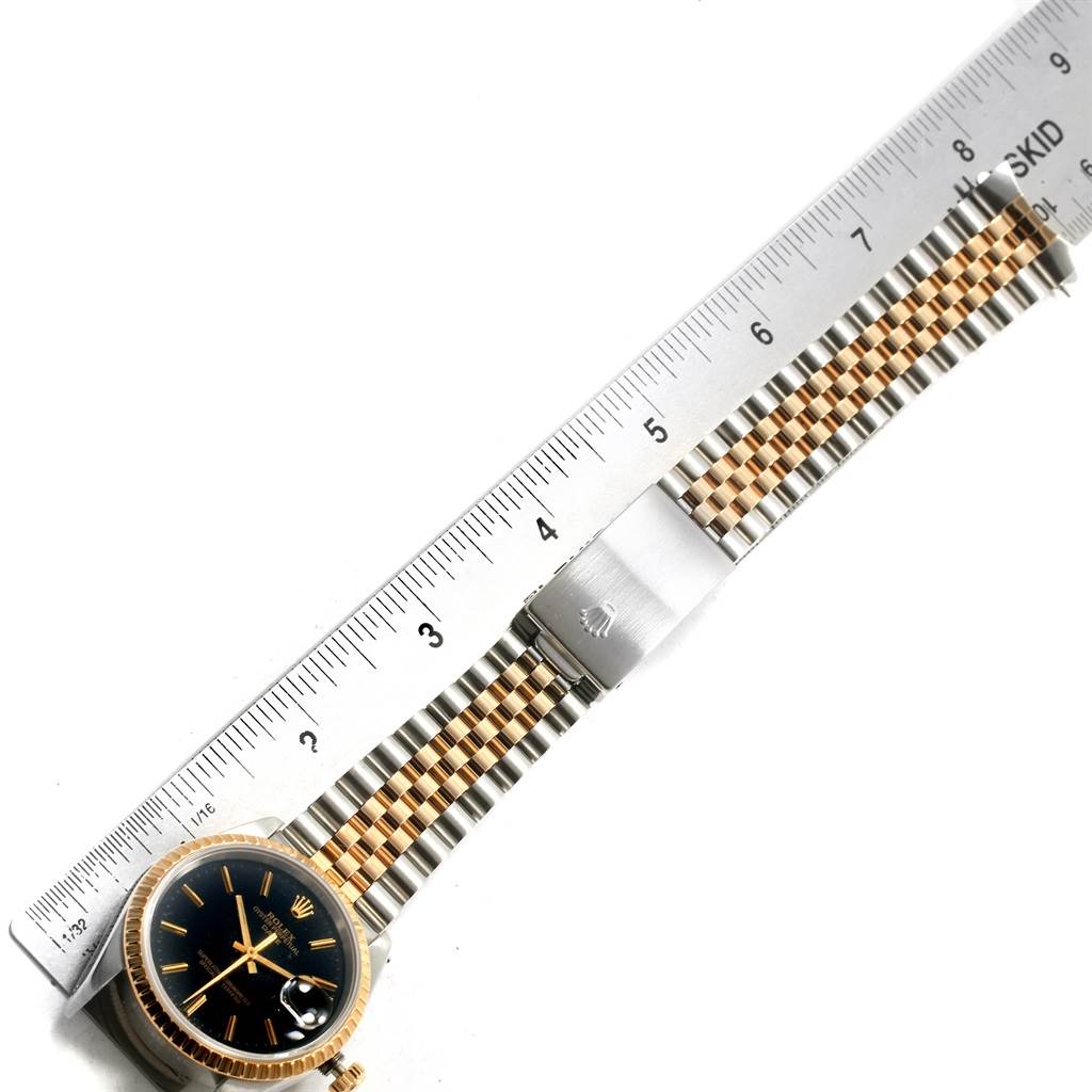 This image shows a Rolex Date 15223 Men's Steel and Gold (two tone) Black Dial 15223 Men's Steel and Gold (two tone) Black Dial watch with a black dial and a two-tone bracelet measured against a ruler.