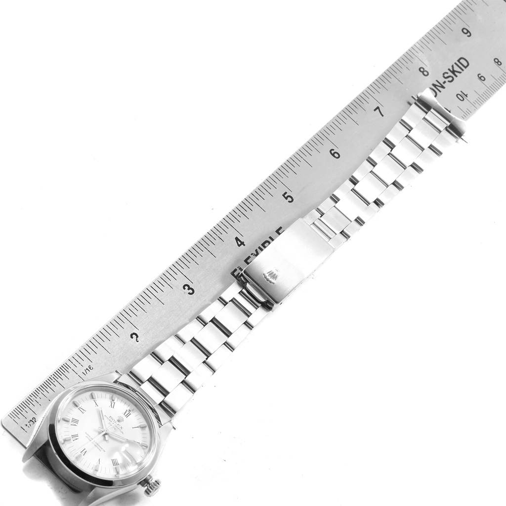 The image shows a Rolex Date 1500 Men's Stainless Steel White Dial 1500 Men's Stainless Steel White Dial model watch positioned next to a ruler, focusing on the bracelet and clasp.