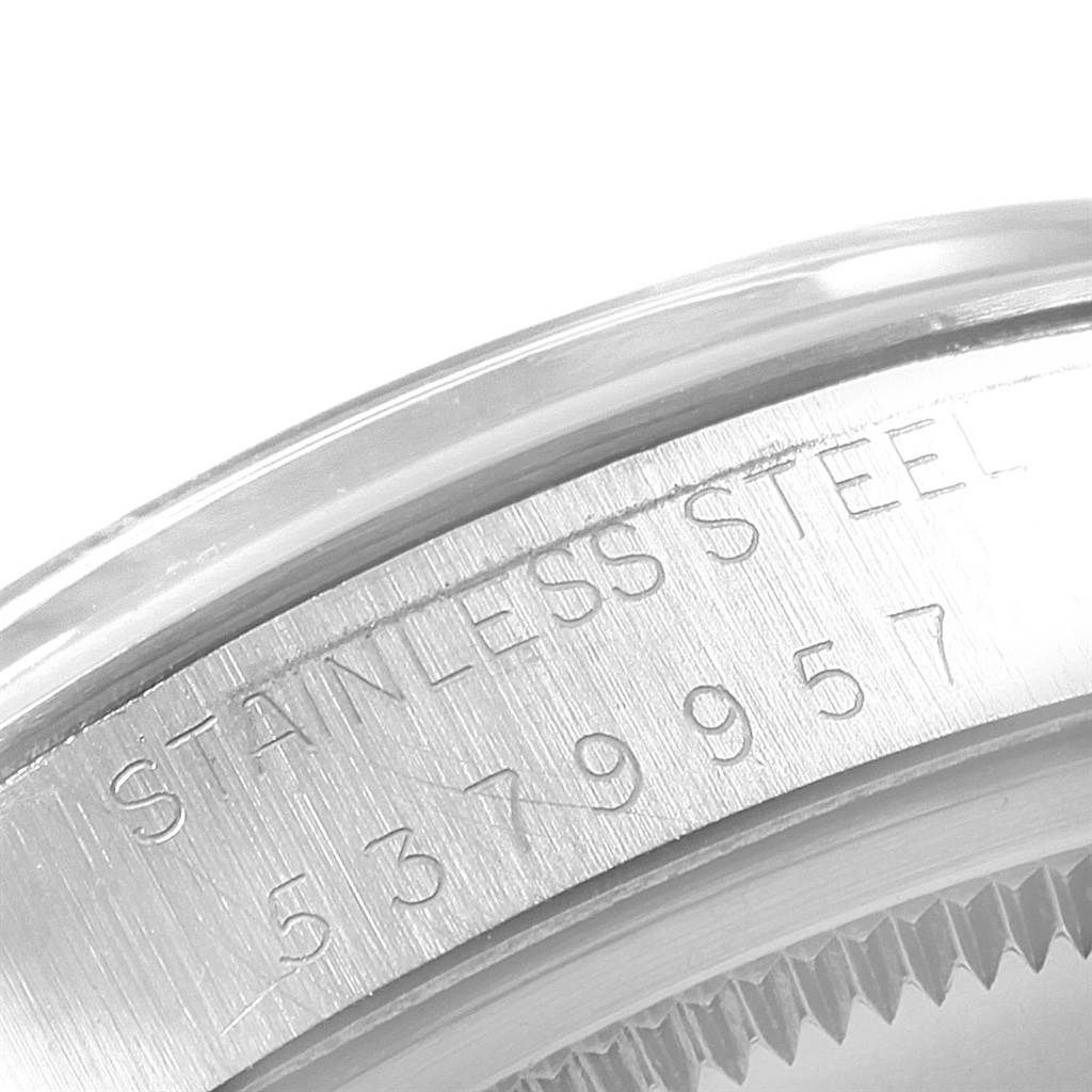 This image shows the side of the stainless steel case and part of the bezel of a Rolex Date 1500 Men's Stainless Steel White Dial 1500 Men's Stainless Steel White Dial watch.