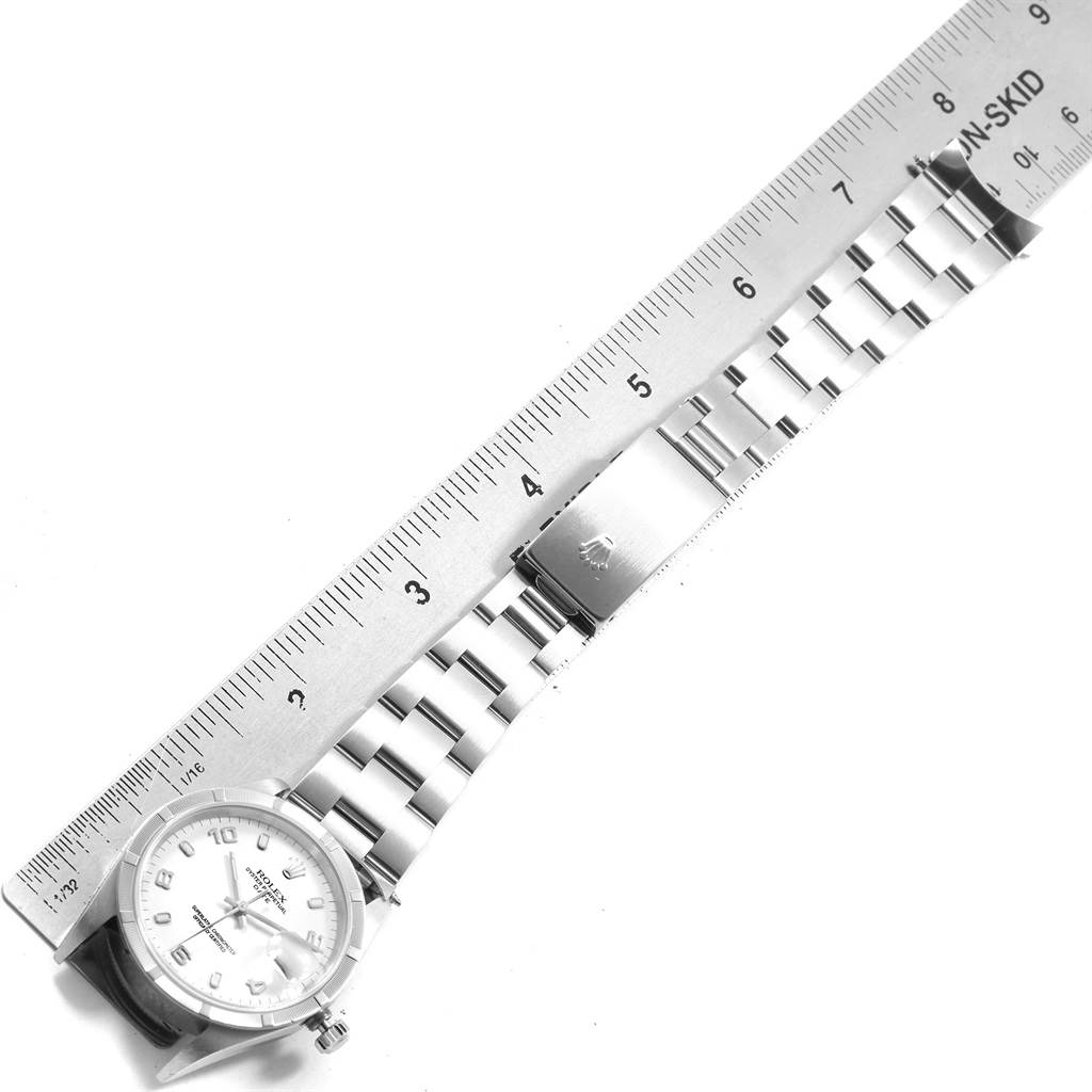 The image shows a top-down view of a Rolex Date 15210 Men's Stainless Steel White Dial 15210 Men's Stainless Steel White Dial model watch with its band extended alongside a ruler.