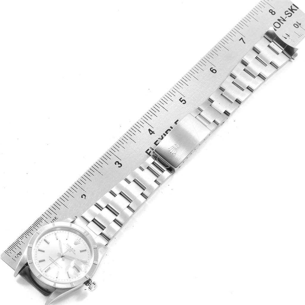 This image shows a top view of a Rolex Date 15210 Men's Stainless Steel Silver Dial 15210 Men's Stainless Steel Silver Dial model watch with its bracelet fully extended and measured alongside a ruler.