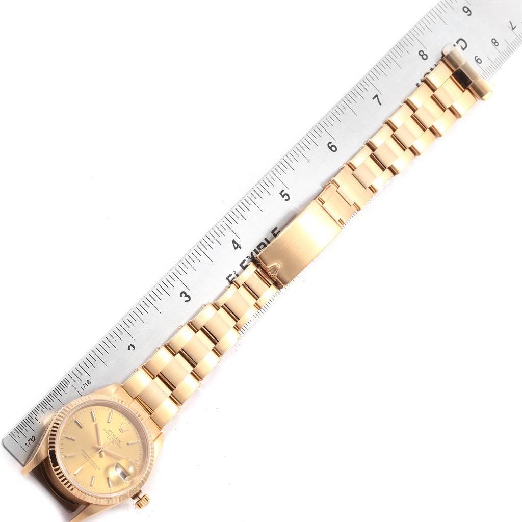 The image shows a Rolex Date 15238 Men's Yellow Gold Champagne Dial 15238 Men's Yellow Gold Champagne Dial model watch laid flat next to a ruler, displaying the watch face and entire bracelet.