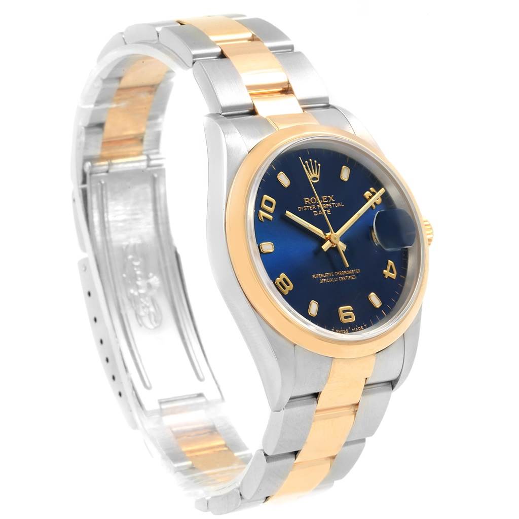 The image shows a Rolex Date 15203 Men's Steel and Gold (two tone) Blue Dial 15203 Men's Steel and Gold (two tone) Blue Dial watch from a front-left angle, highlighting its blue dial, gold bezel, and two-tone bracelet.