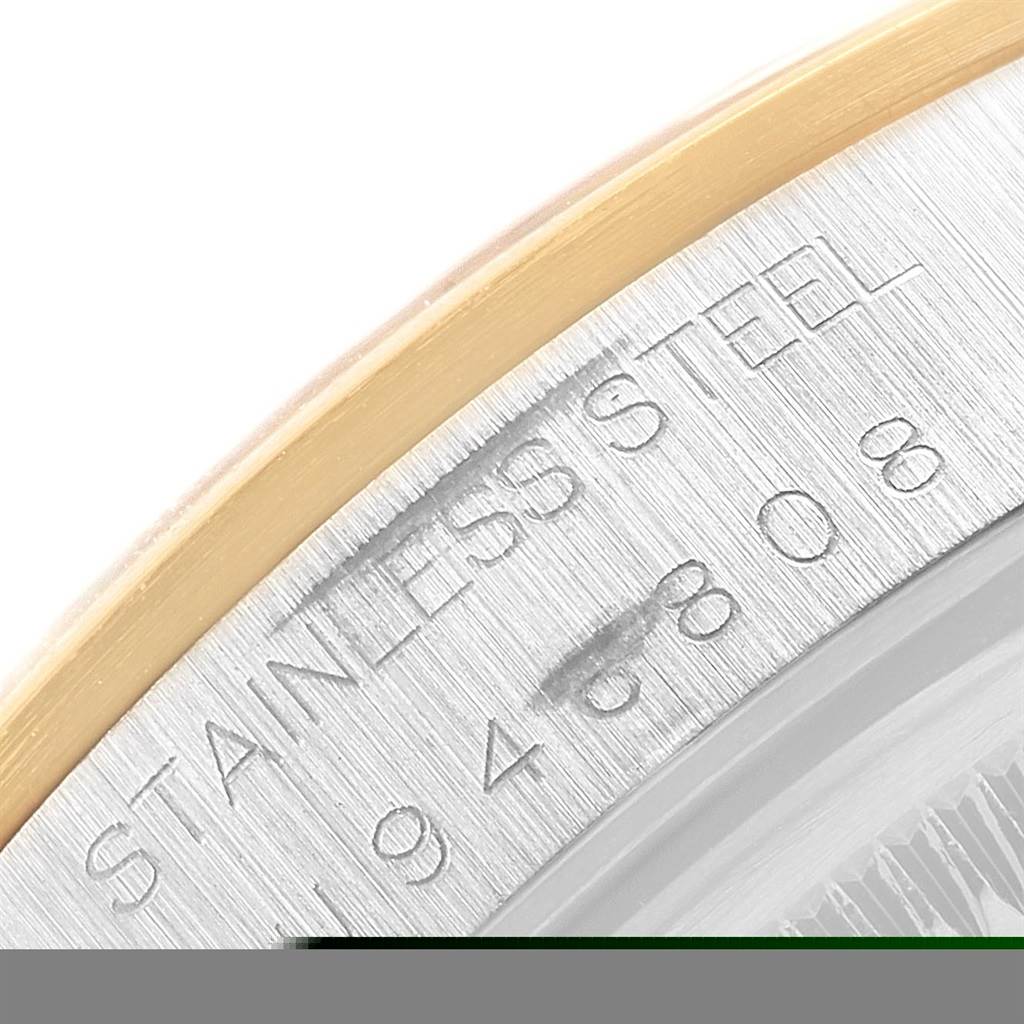 The image shows a close-up of the serial number and "Stainless Steel" engraving on a Rolex Date 15203 Men's Steel and Gold (two tone) Blue Dial 15203 Men's Steel and Gold (two tone) Blue Dial model watch case.