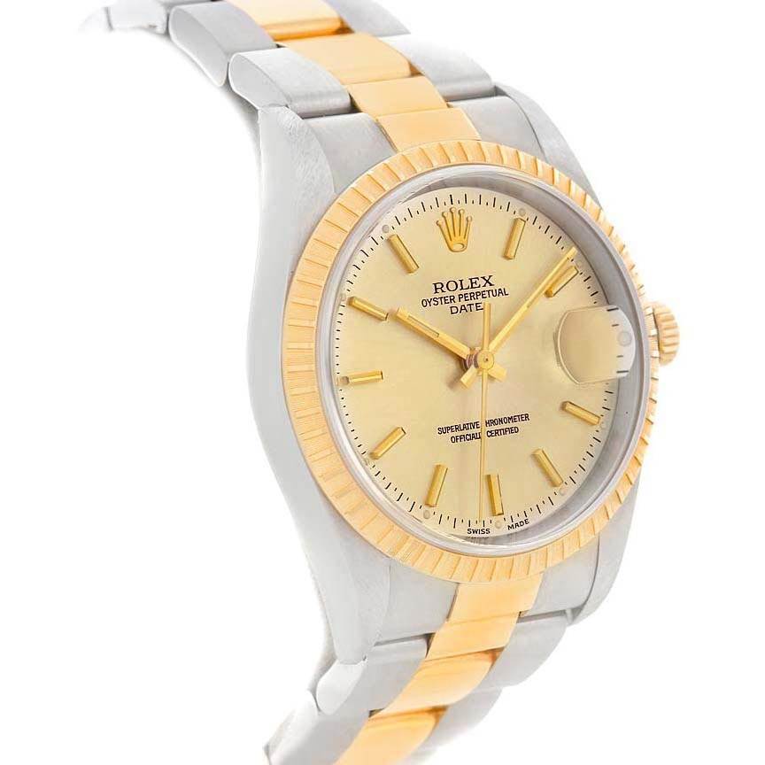 The image shows a Rolex Oyster Perpetual Date model watch at a slight angle, highlighting its bezel, crown, and two-tone band.