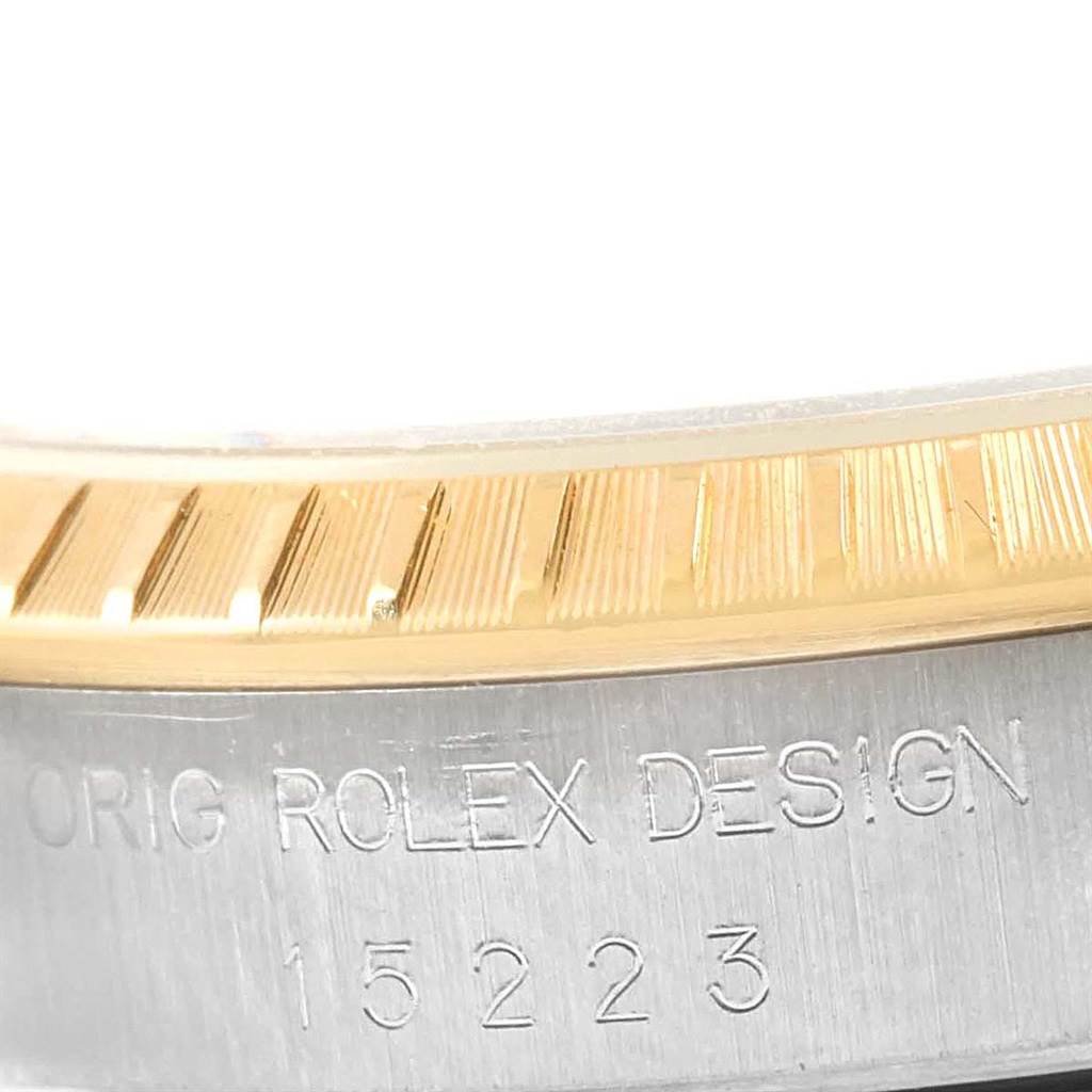 This close-up image shows the engraved side of a Rolex Date 15223 Men's Steel and Gold (two tone) White Dial 15223 Men's Steel and Gold (two tone) White Dial model, highlighting the bezel and serial number.