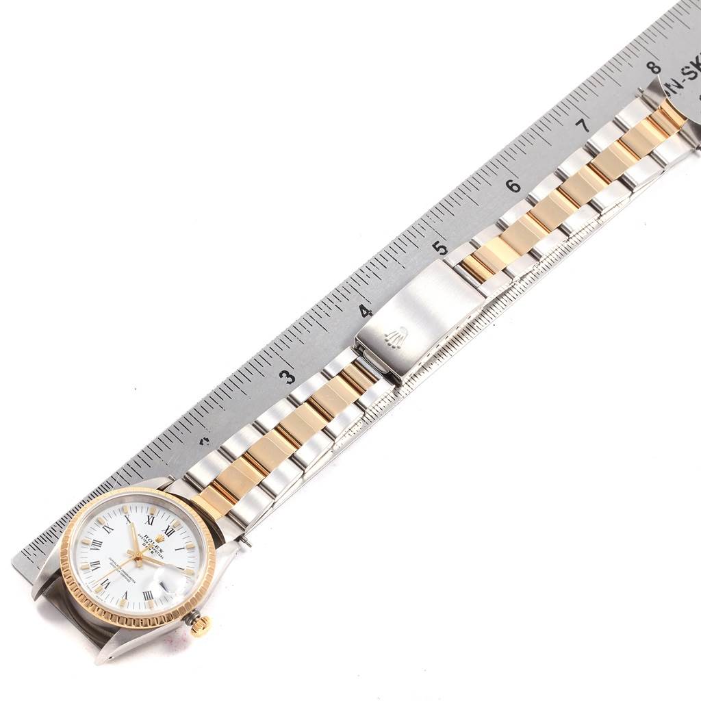 The image shows a top view of the Rolex Date 15223 Men's Steel and Gold (two tone) White Dial 15223 Men's Steel and Gold (two tone) White Dial model watch, highlighting the face, bezel, and two-tone bracelet alongside a ruler.