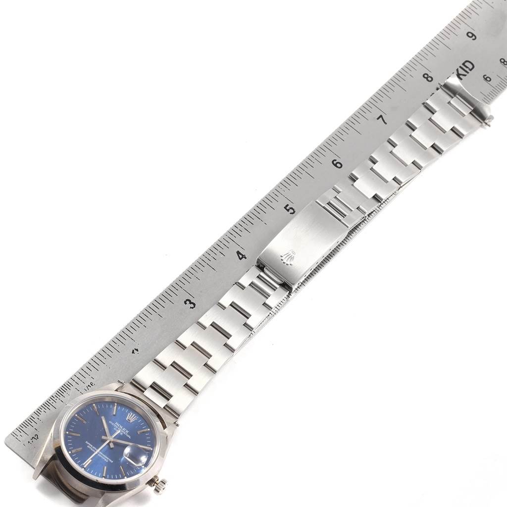 This image shows a Rolex Date 15200 Men's Stainless Steel Blue Dial 15200 Men's Stainless Steel Blue Dial model watch in a horizontal position with its full metal bracelet and clasp against a ruler.