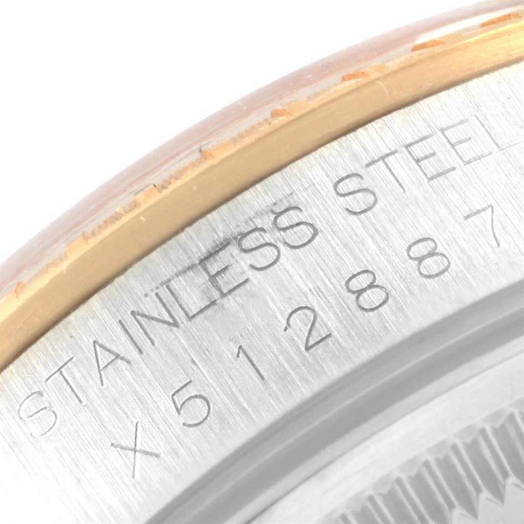 The image shows a close-up of the engraving on the side of the bezel of a Rolex Date 15223 Men's Steel and Gold (two tone) White Dial 15223 Men's Steel and Gold (two tone) White Dial watch, highlighting "STAINLESS STEEL" and a serial number.