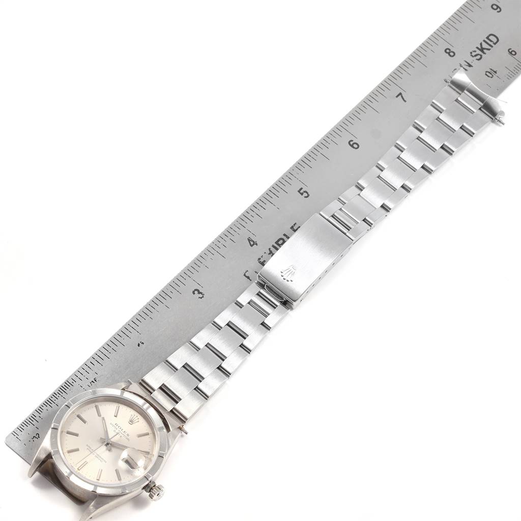 The image shows a Rolex Date 15210 Men's Stainless Steel Silver Dial 15210 Men's Stainless Steel Silver Dial model watch laid flat with its bracelet fully visible against a ruler for size reference.