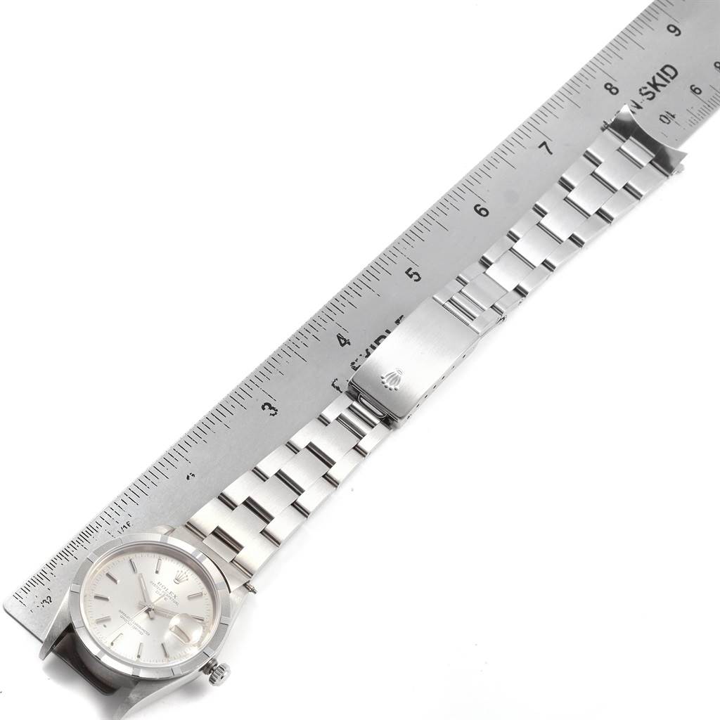 The image shows a Rolex Date 15210 Men's Stainless Steel Silver Dial 15210 Men's Stainless Steel Silver Dial model watch laid flat next to a ruler, displaying the dial, bracelet, and clasp.