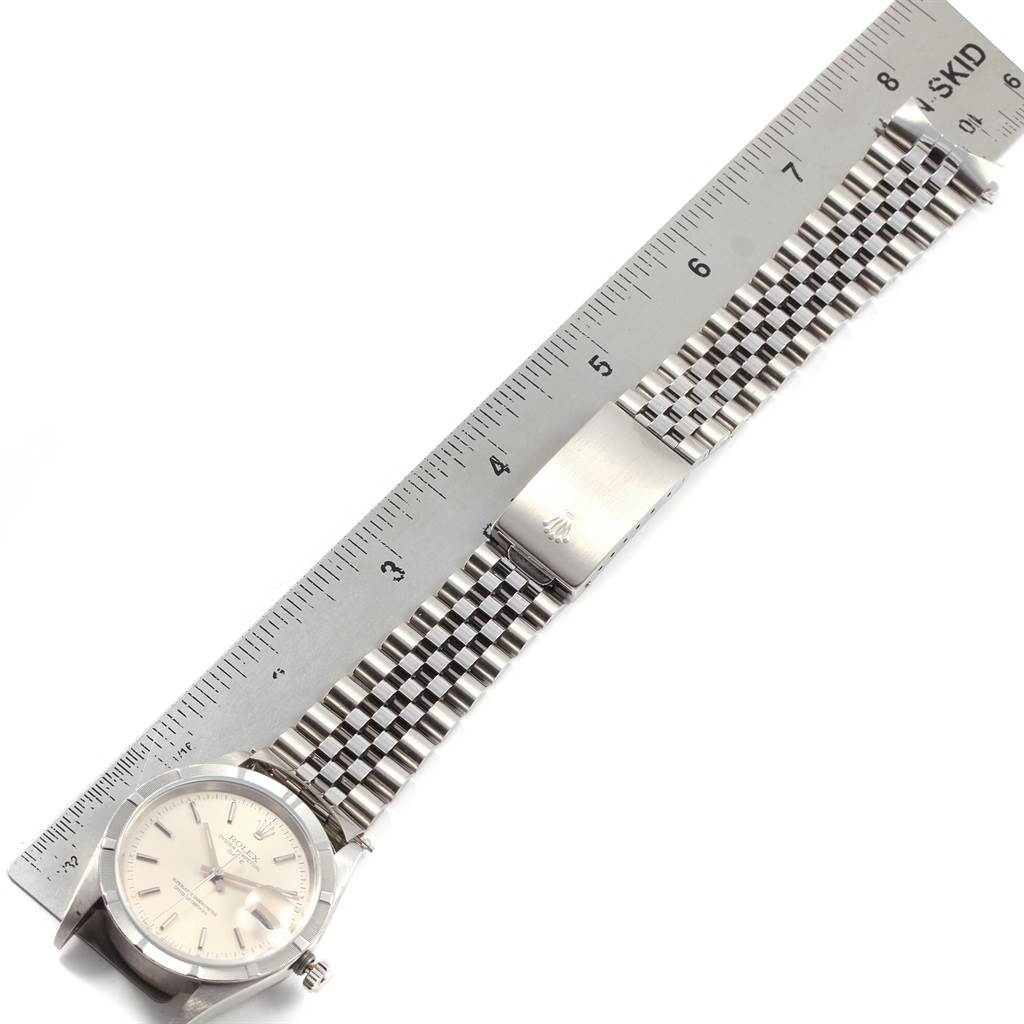 The image shows the Rolex Date 15210 Men's Stainless Steel Silver Dial 15210 Men's Stainless Steel Silver Dial model watch laid flat with a portion of the bracelet beside a ruler for measurement.