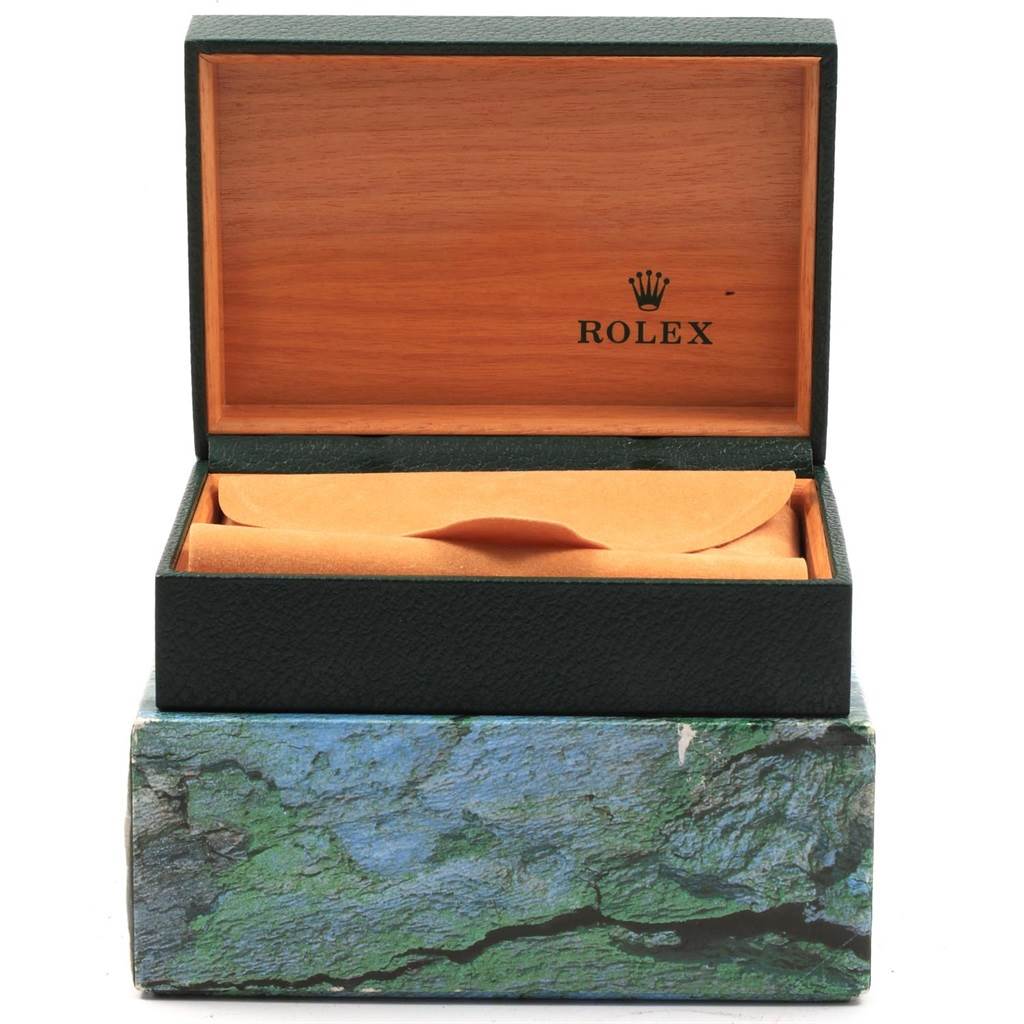 This image shows an open Rolex Date 15210 Men's Stainless Steel Silver Dial 15210 Men's Stainless Steel Silver Dial model watch box, featuring a wooden interior and an orange envelope inside.