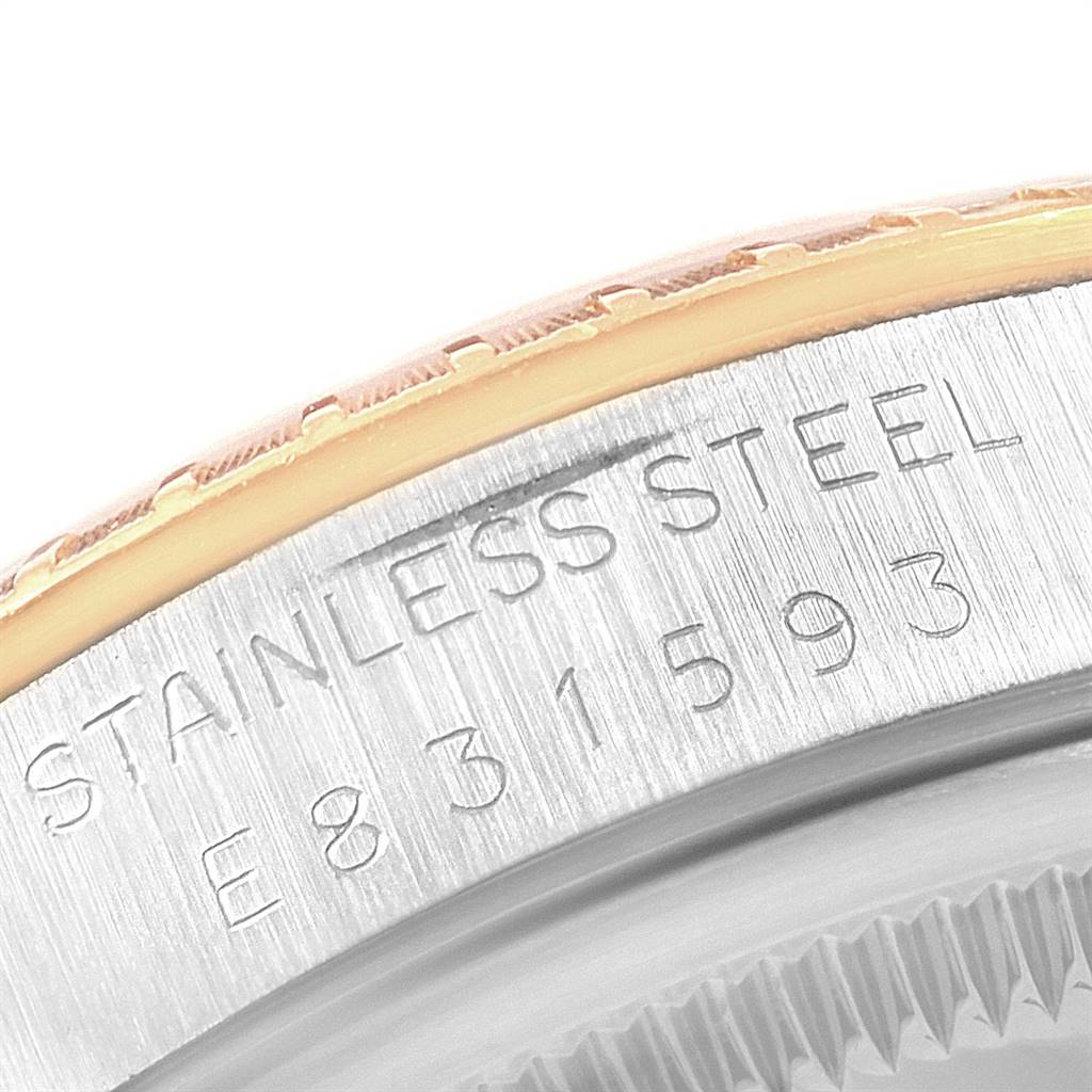 This image shows a close-up of the case back and edge of the bezel of a Rolex Date 15223 Men's Steel and Gold (two tone) White Dial 15223 Men's Steel and Gold (two tone) White Dial model watch with "STAINLESS STEEL" engraved.