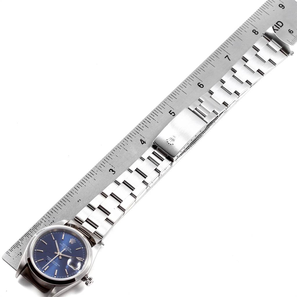 This top-down image shows a Rolex Date 15200 Men's Stainless Steel Blue Dial 15200 Men's Stainless Steel Blue Dial watch with a blue dial, metal bracelet, and clasp, along with a ruler.