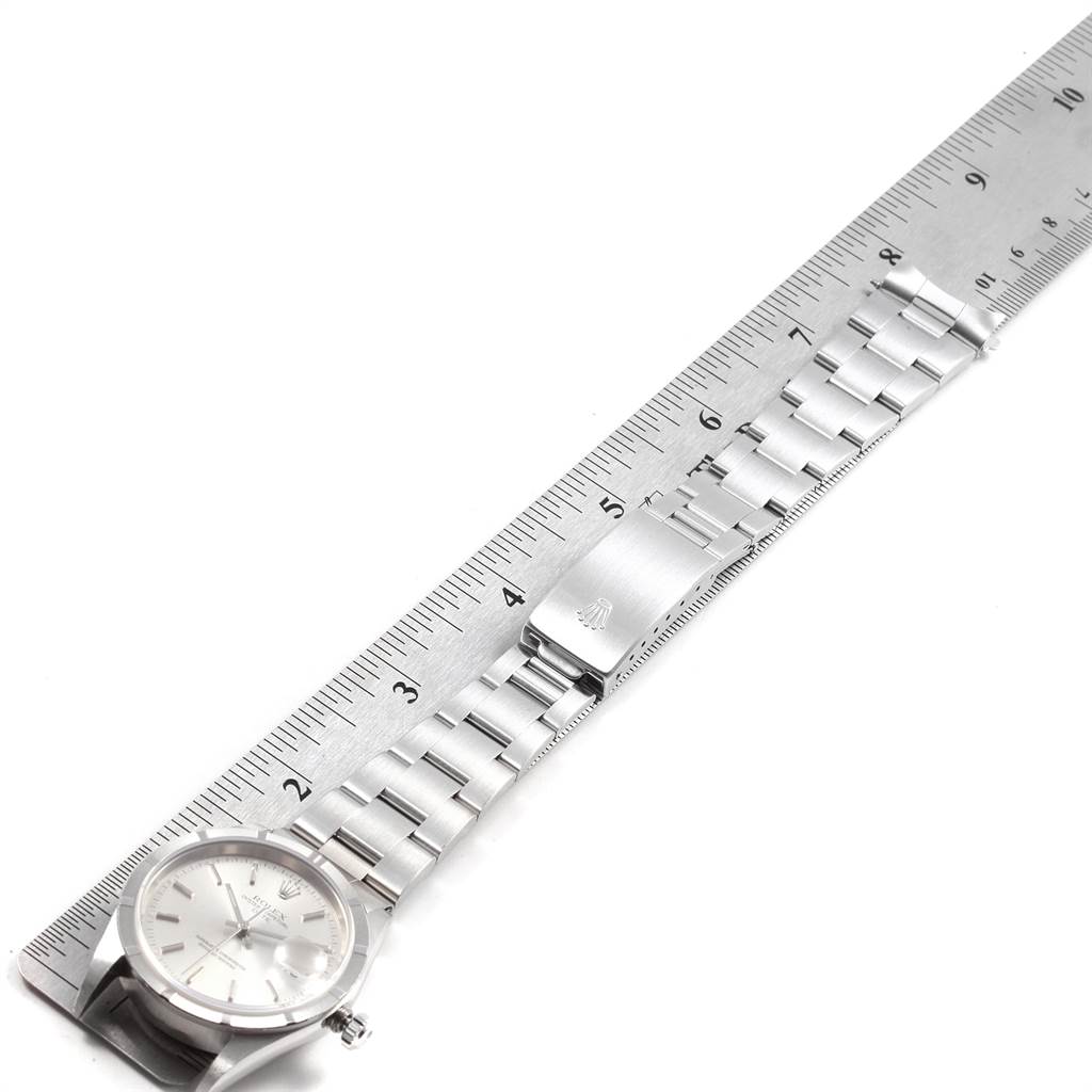 The image shows a Rolex Date 15210 Men's Stainless Steel Silver Dial 15210 Men's Stainless Steel Silver Dial model watch laid flat with the stainless steel bracelet extended, next to a ruler for measurement.