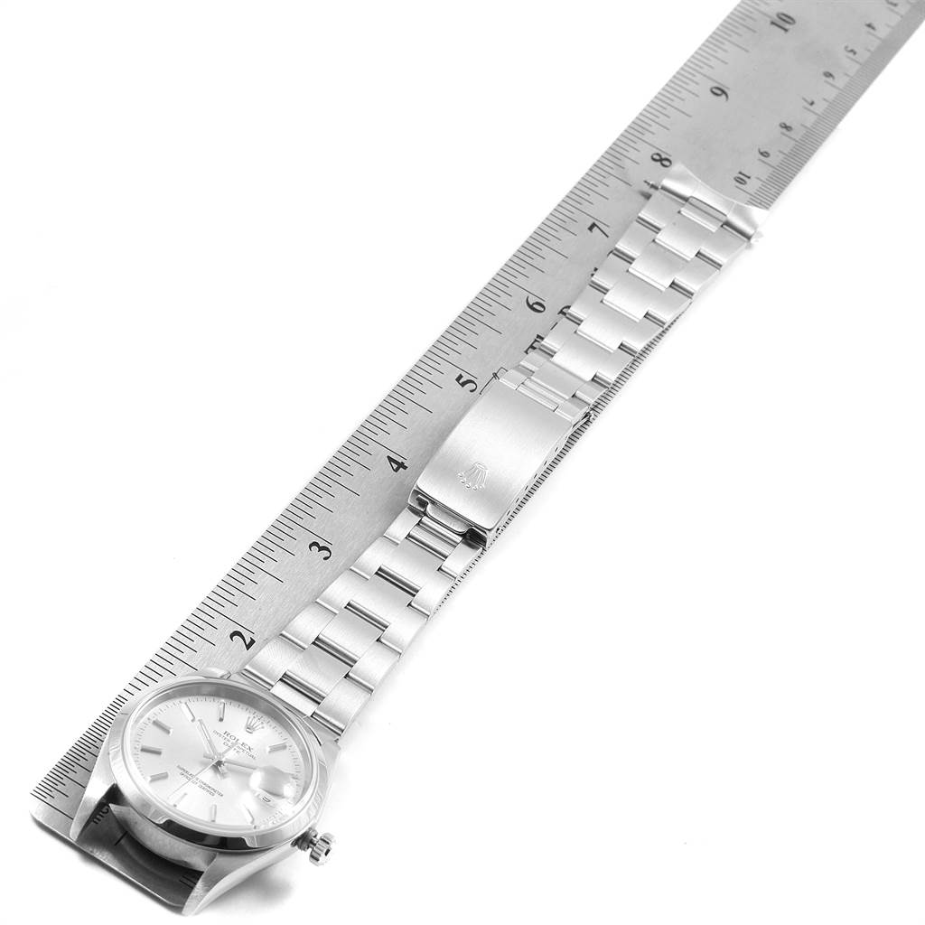The Rolex Date 15200 Men's Stainless Steel Silver Dial 15200 Men's Stainless Steel Silver Dial watch is shown laid flat, extended alongside a ruler, displaying the face, bracelet, and clasp.