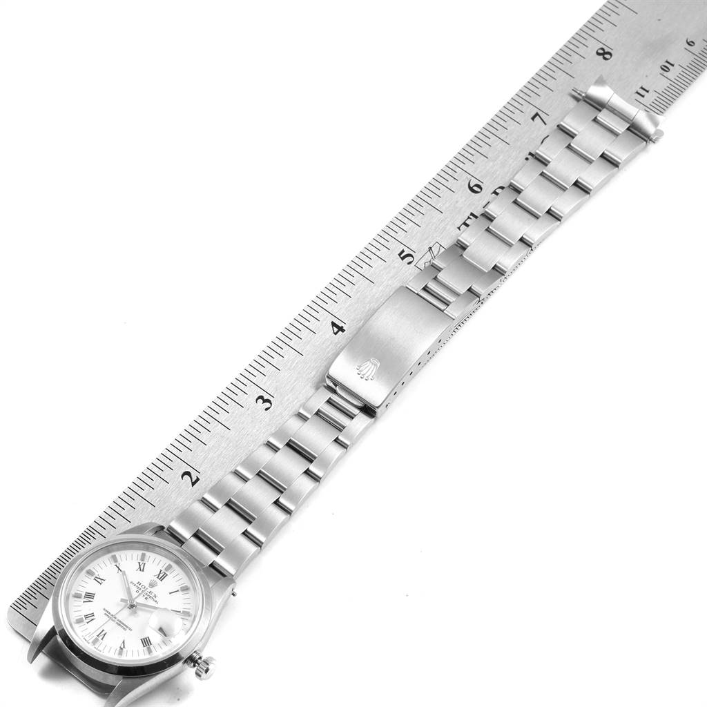 The image shows a Rolex Date 15200 Men's Stainless Steel White Dial 15200 Men's Stainless Steel White Dial watch laid flat with its stainless steel bracelet parallel to a ruler for measurement.