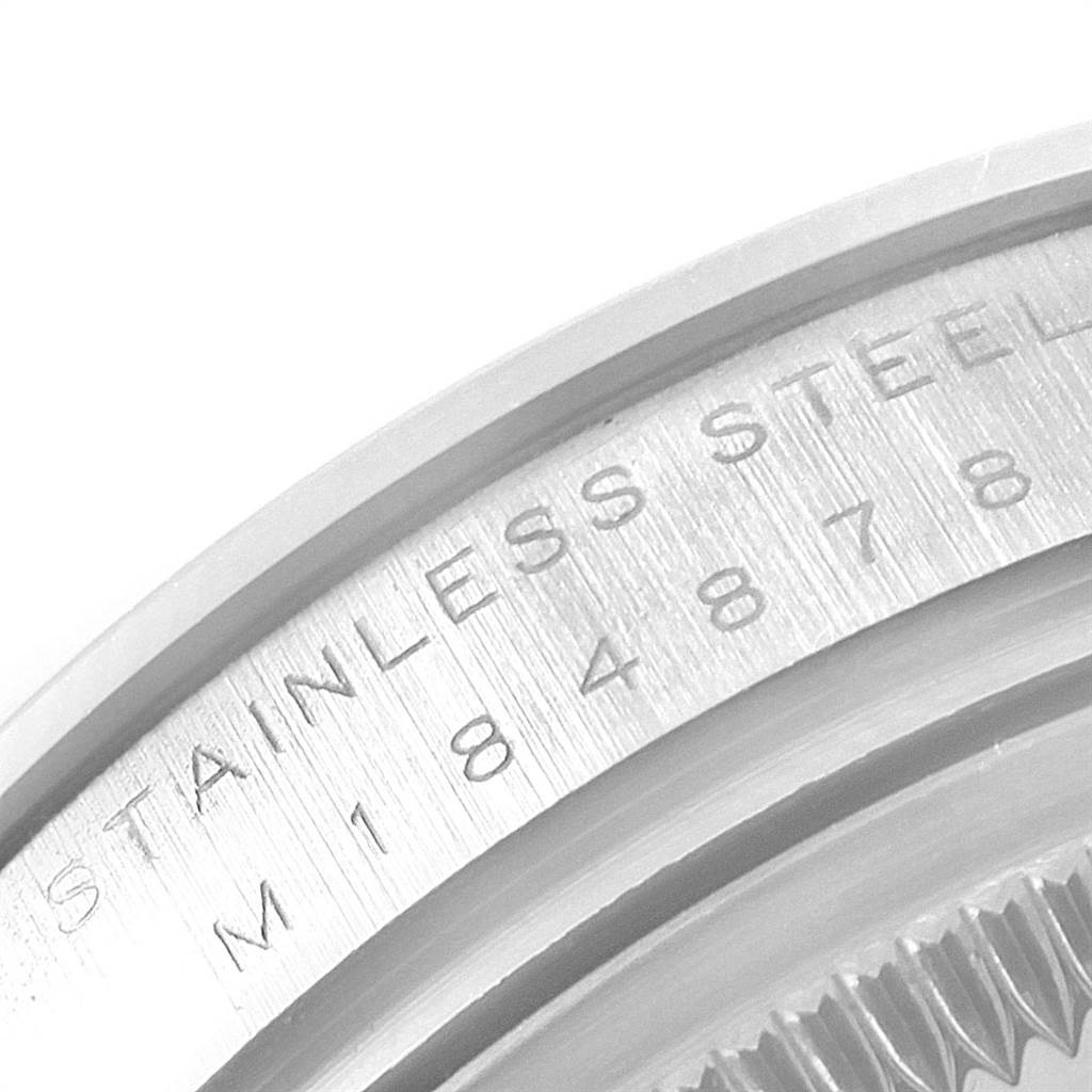This image shows a close-up of the side of the stainless steel bezel of a Rolex Date 115200 Men's Stainless Steel Pink Dial 115200 Men's Stainless Steel Pink Dial model watch.