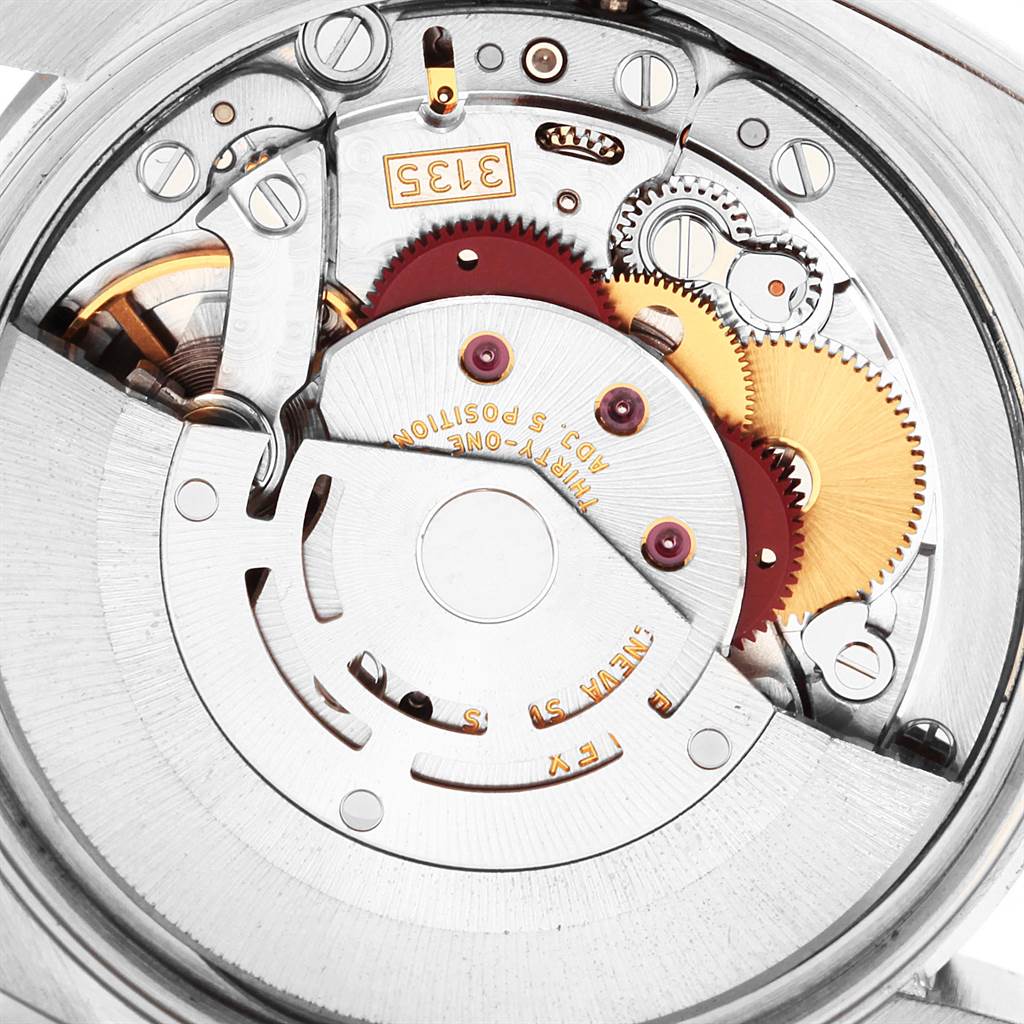This image shows a close-up view of the internal mechanism of a Rolex Date 115200 Men's Stainless Steel Pink Dial 115200 Men's Stainless Steel Pink Dial model watch, highlighting gears and other movement parts.