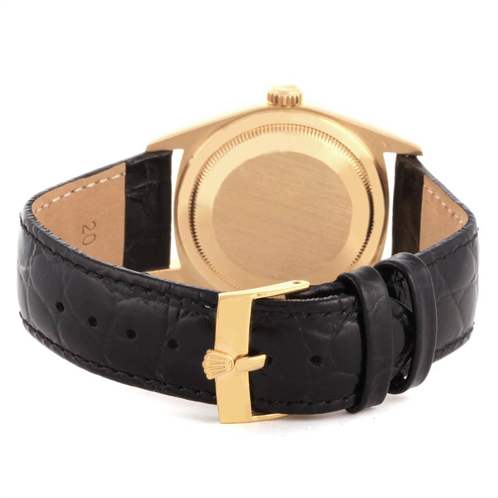 The image shows the back of the Rolex Date 16238 Men's Yellow Gold Champagne Dial 16238 Men's Yellow Gold Champagne Dial model watch with a gold case and black leather strap and buckle.