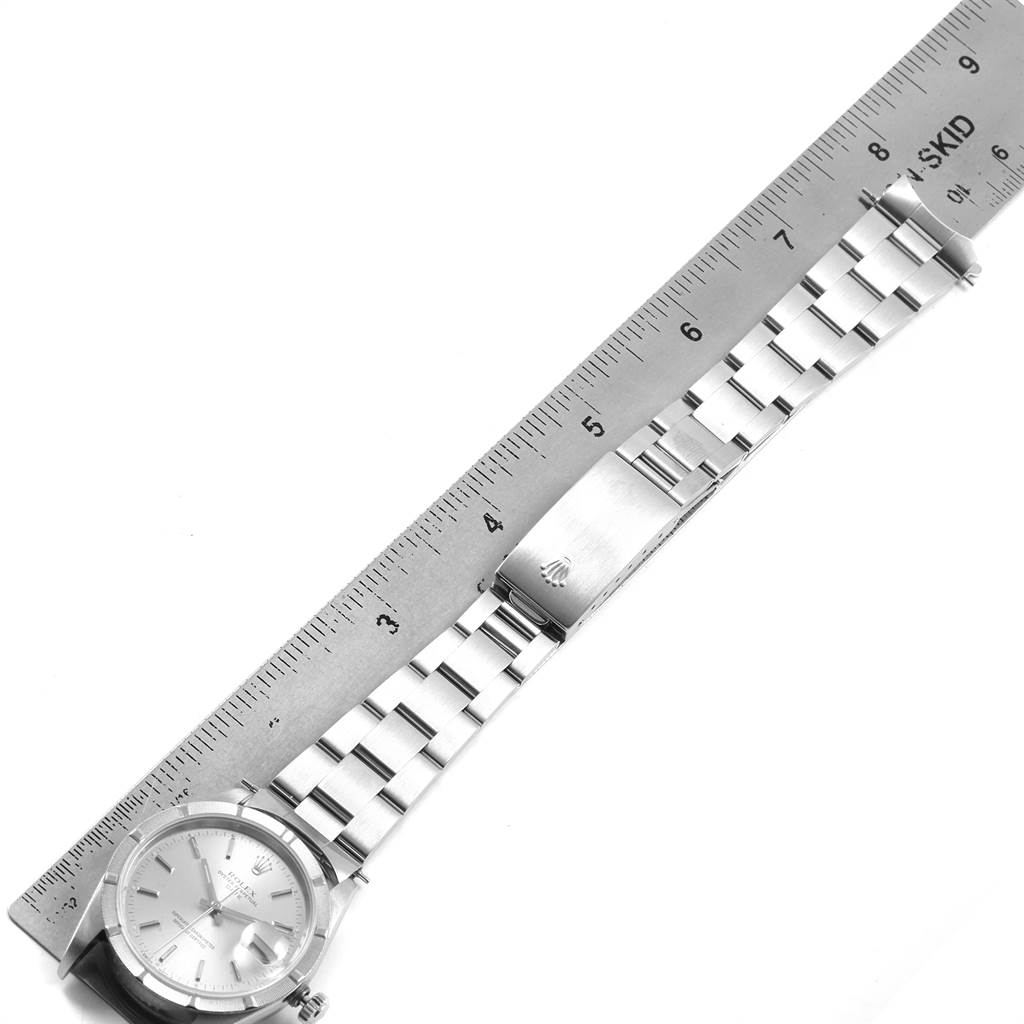 The image shows a Rolex Date 15210 Men's Stainless Steel Silver Dial 15210 Men's Stainless Steel Silver Dial model watch laid flat, highlighting the dial, bracelet, and clasp alongside a ruler for scale.