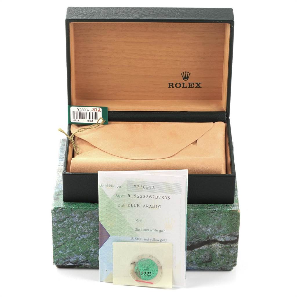 The image shows an open box containing a Rolex Date 15223 Men's Steel and Gold (two tone) Blue Dial 15223 Men's Steel and Gold (two tone) Blue Dial model watch with accompanying documents and authenticity card.