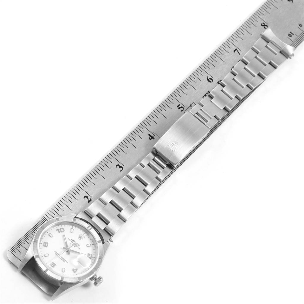 The image shows a Rolex Date 15210 Men's Stainless Steel White Dial 15210 Men's Stainless Steel White Dial model watch laid flat next to a ruler, displaying the case, bracelet, and clasp.