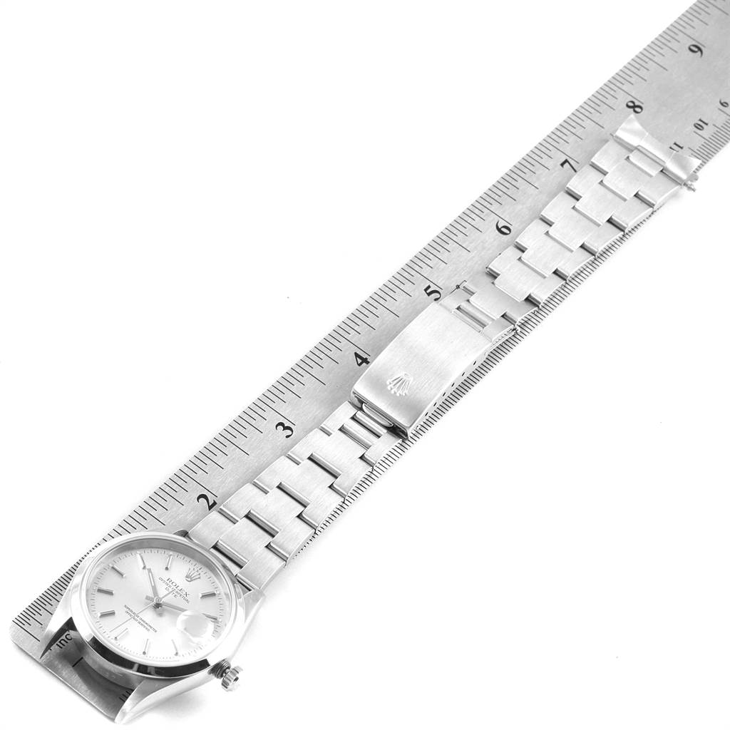 The image shows a Rolex Date 15200 Men's Stainless Steel Silver Dial 15200 Men's Stainless Steel Silver Dial model watch with its face, bracelet, and clasp lying flat against a ruler.