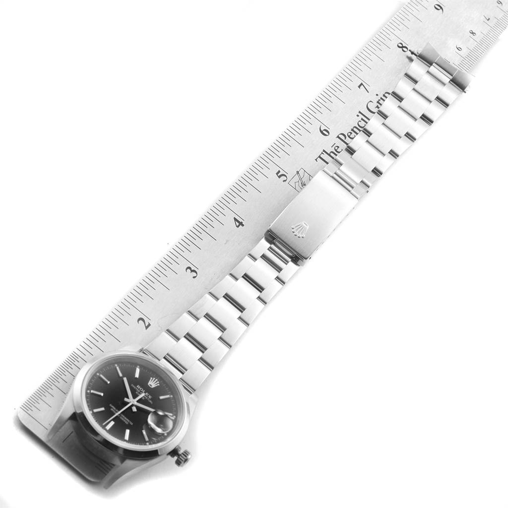 The image shows a Rolex Date 15200 Men's Stainless Steel Black Dial 15200 Men's Stainless Steel Black Dial watch model laid flat against a ruler, displaying its face, bracelet, and clasp.