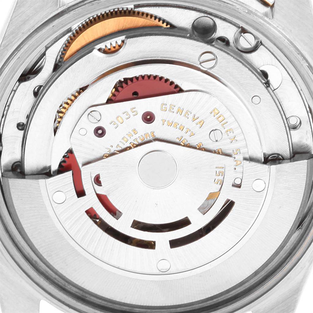 This is a close-up of the Rolex Date 15053 Men's Steel and Gold (two tone) Champagne Dial 15053 Men's Steel and Gold (two tone) Champagne Dial model's movement showing gears, rotor, and engraved details.