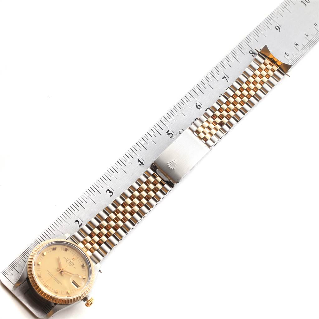 The image shows a Rolex Date 15053 Men's Steel and Gold (two tone) Champagne Dial 15053 Men's Steel and Gold (two tone) Champagne Dial model watch face and bracelet, accompanied by a ruler for measurement.