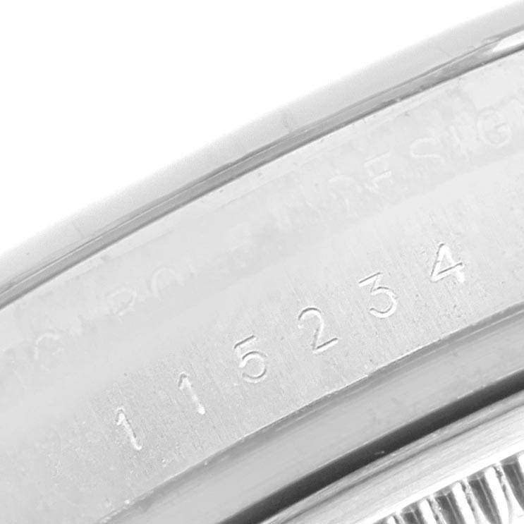 This image shows a close-up of the serial number engraved on the case of a Rolex Date 115234 Men's Stainless Steel Silver Dial 115234 Men's Stainless Steel Silver Dial model watch.