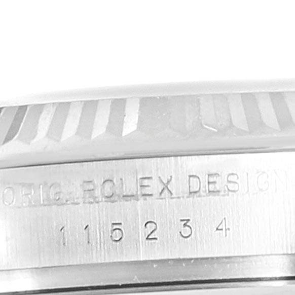 The image shows a close-up side view of the Rolex Date 115234 Men's Stainless Steel White Dial 115234 Men's Stainless Steel White Dial model watch, highlighting its bezel and engraved serial number.
