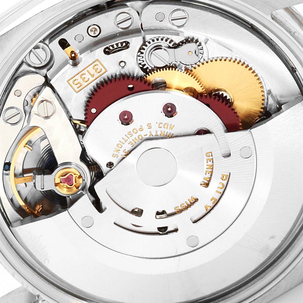 The image shows a close-up angle of the internal mechanism of the Rolex Date 115234 Men's Stainless Steel White Dial 115234 Men's Stainless Steel White Dial watch, highlighting gears and the rotor.