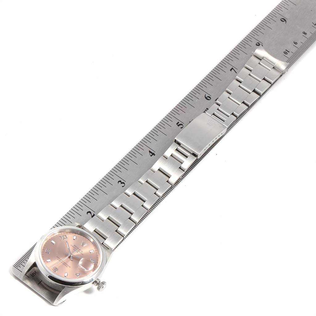 The image shows a Rolex Date 15200 Men's Stainless Steel Pink Dial 15200 Men's Stainless Steel Pink Dial model watch lying flat alongside a ruler, displaying the dial, bracelet, and clasp.