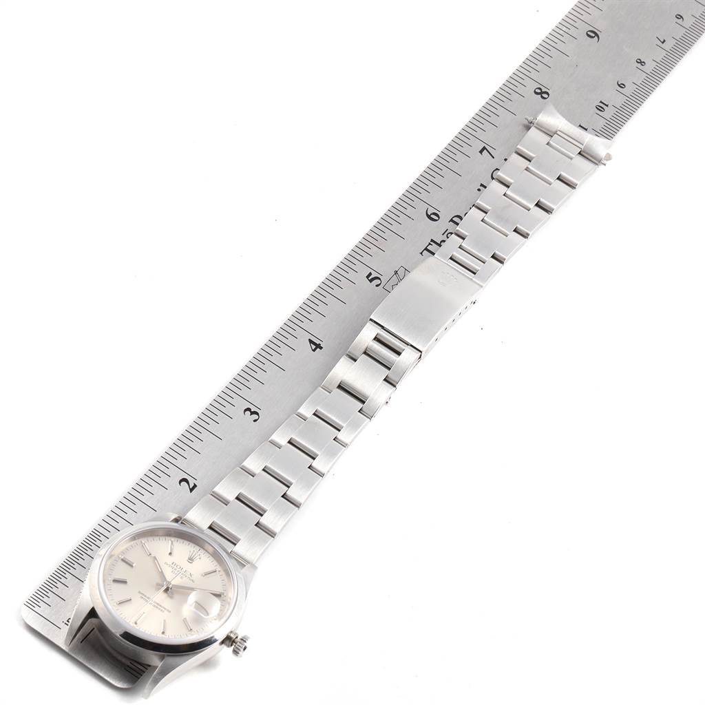 The image shows a Rolex Date 15200 Men's Stainless Steel Silver Dial 15200 Men's Stainless Steel Silver Dial model watch laid flat against a ruler, displaying the face, bracelet, and clasp.