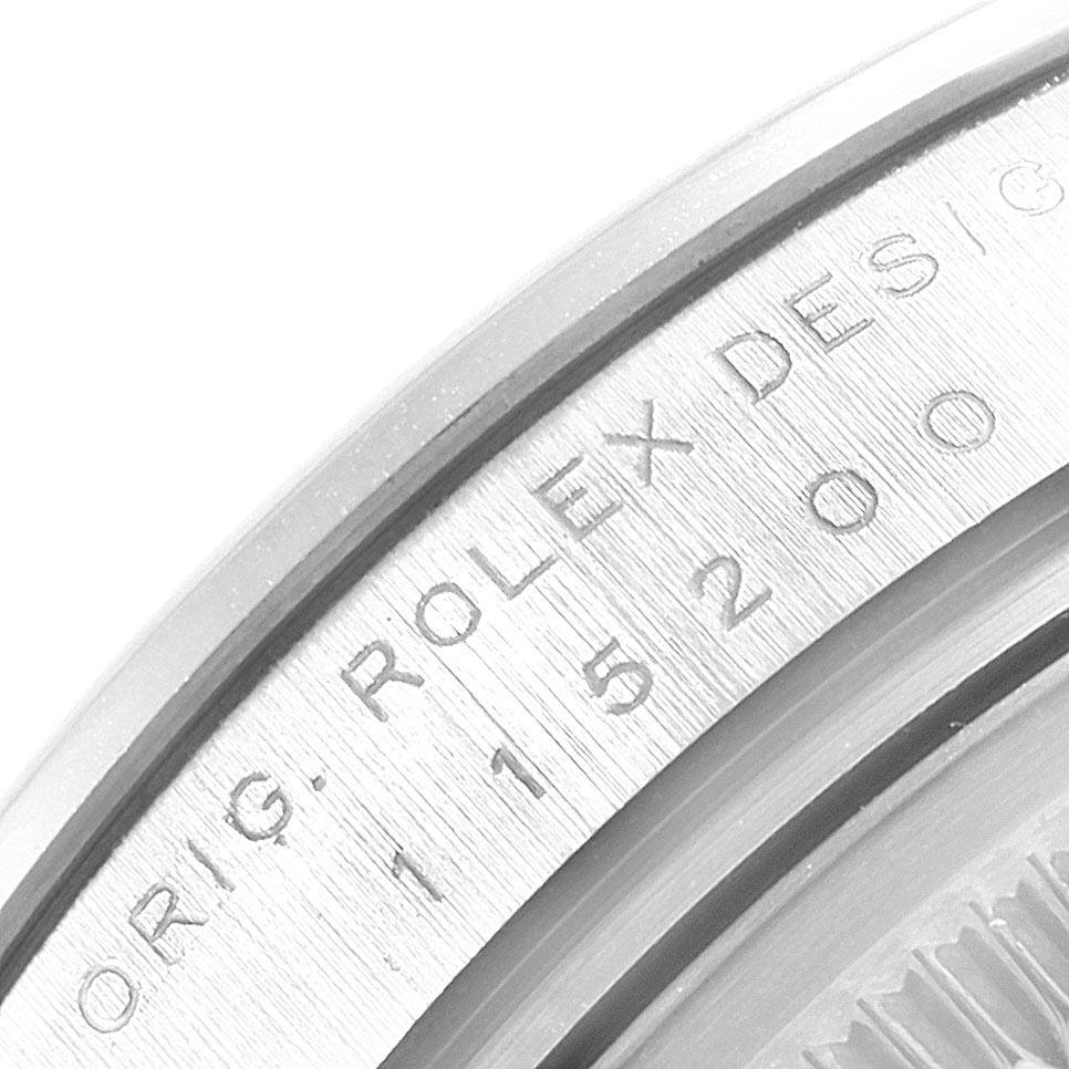 This close-up image shows the model and design engraving on the edge of a Rolex Date 115200 Men's Stainless Steel White Dial 115200 Men's Stainless Steel White Dial watch case.