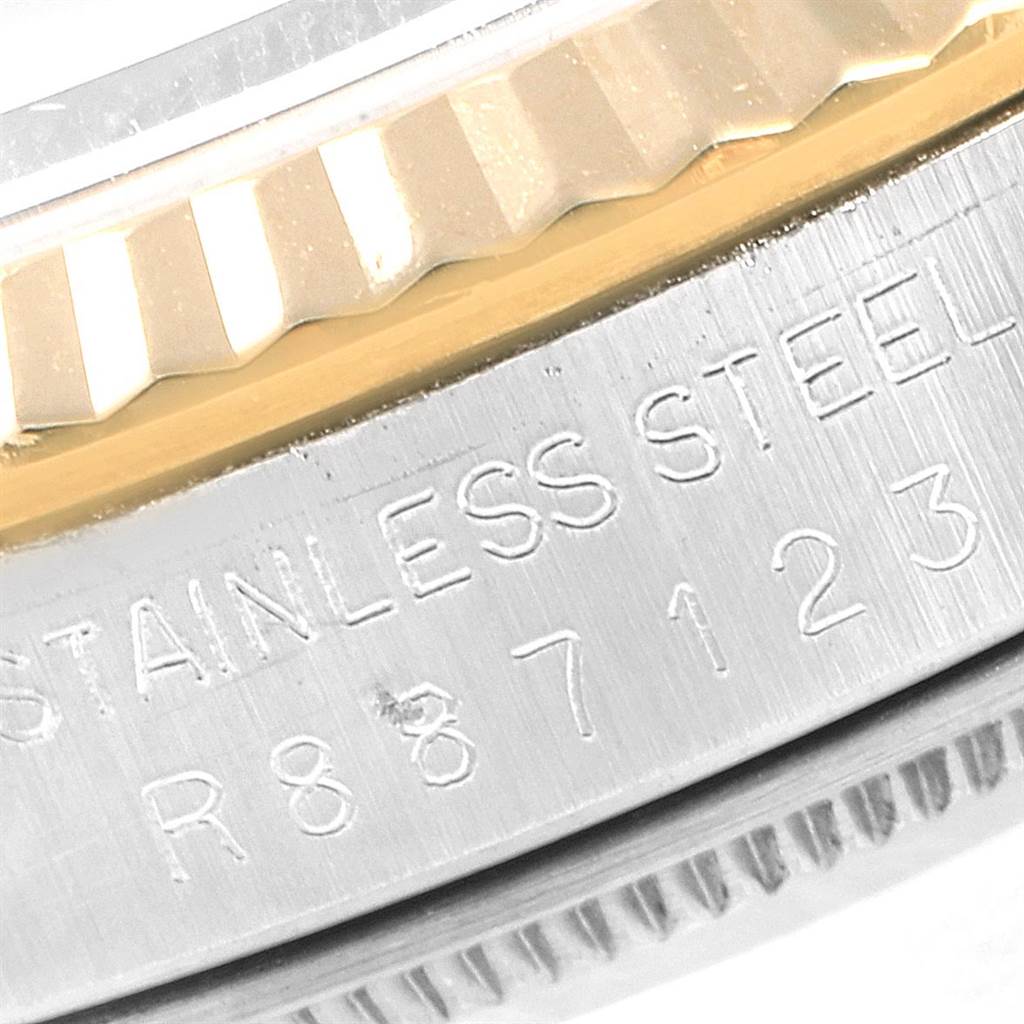 This close-up image of a Rolex Date 16233 Men's Steel and Gold (two tone) Blue Dial 16233 Men's Steel and Gold (two tone) Blue Dial model watch shows part of the stainless steel case and the fluted bezel.