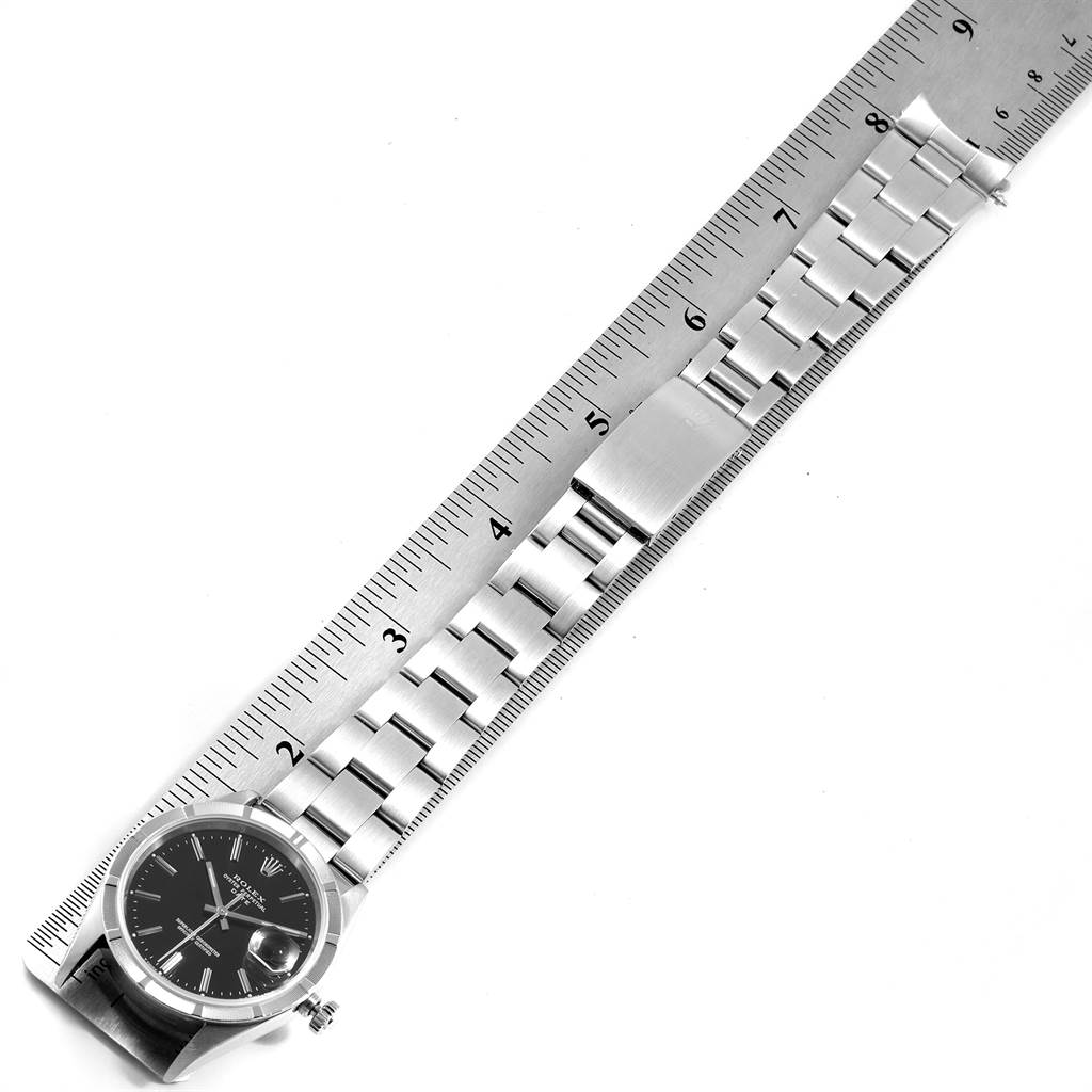 The image shows a Rolex Date 15210 Men's Stainless Steel Black Dial 15210 Men's Stainless Steel Black Dial model watch with its bracelet and clasp, aligned alongside a ruler.