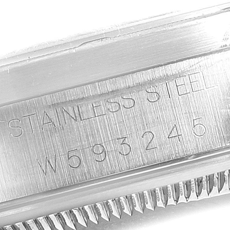 The image shows the side of a Rolex Date 15210 Men's Stainless Steel Black Dial 15210 Men's Stainless Steel Black Dial watch, focusing on the engraved serial number and "STAINLESS STEEL" marking.