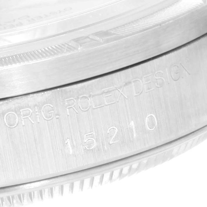 This image shows a close-up of the case side with engraved text and part of the bezel of a Rolex Date 15210 Men's Stainless Steel Blue Dial 15210 Men's Stainless Steel Blue Dial model 15210.