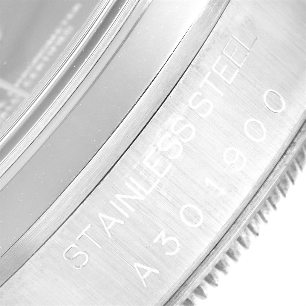 The image shows a close-up of the stainless steel bezel edge of a Rolex Date 15200 Men's Stainless Steel Blue Dial 15200 Men's Stainless Steel Blue Dial model watch, displaying part of its engraved serial number.