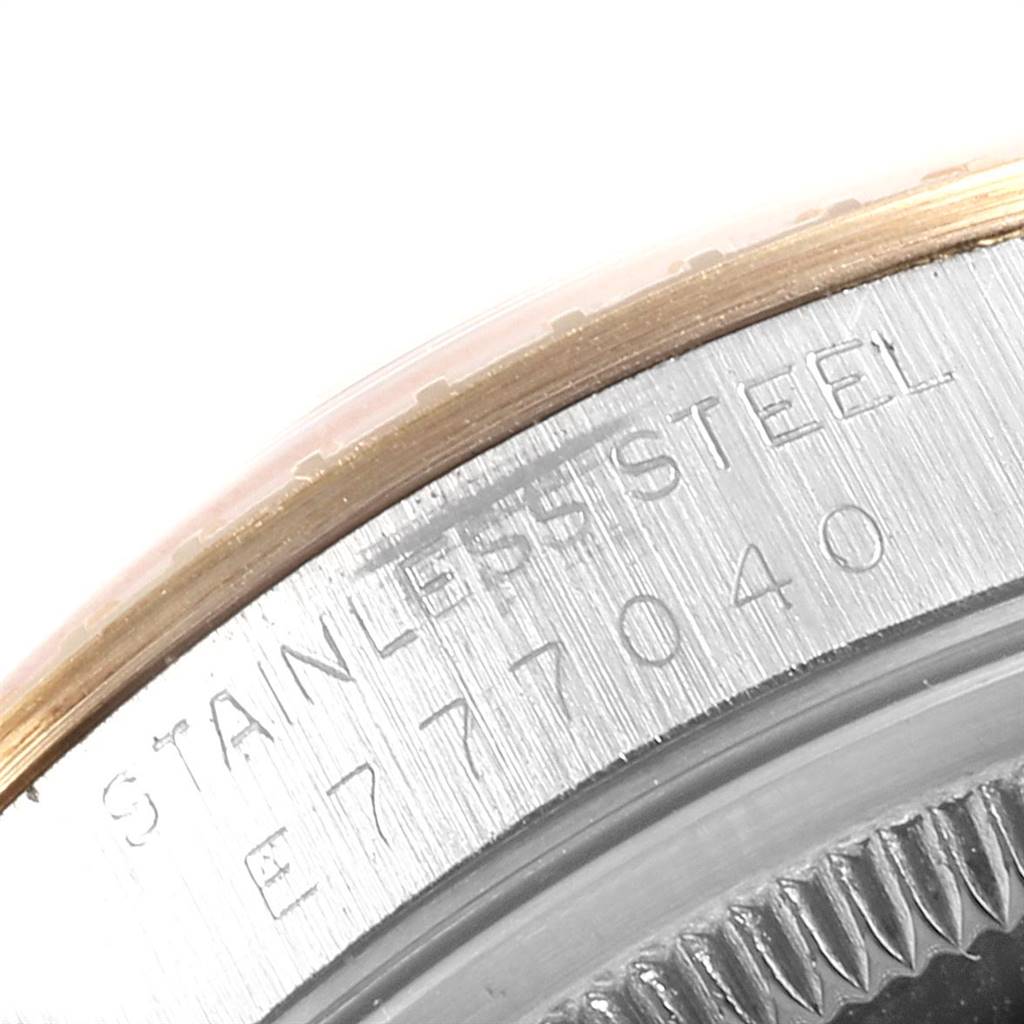 The image shows a close-up of the serial number and "STAINLESS STEEL" imprint on a Rolex Date 15223 Men's Steel and Gold (two tone) Champagne Dial 15223 Men's Steel and Gold (two tone) Champagne Dial model watch.