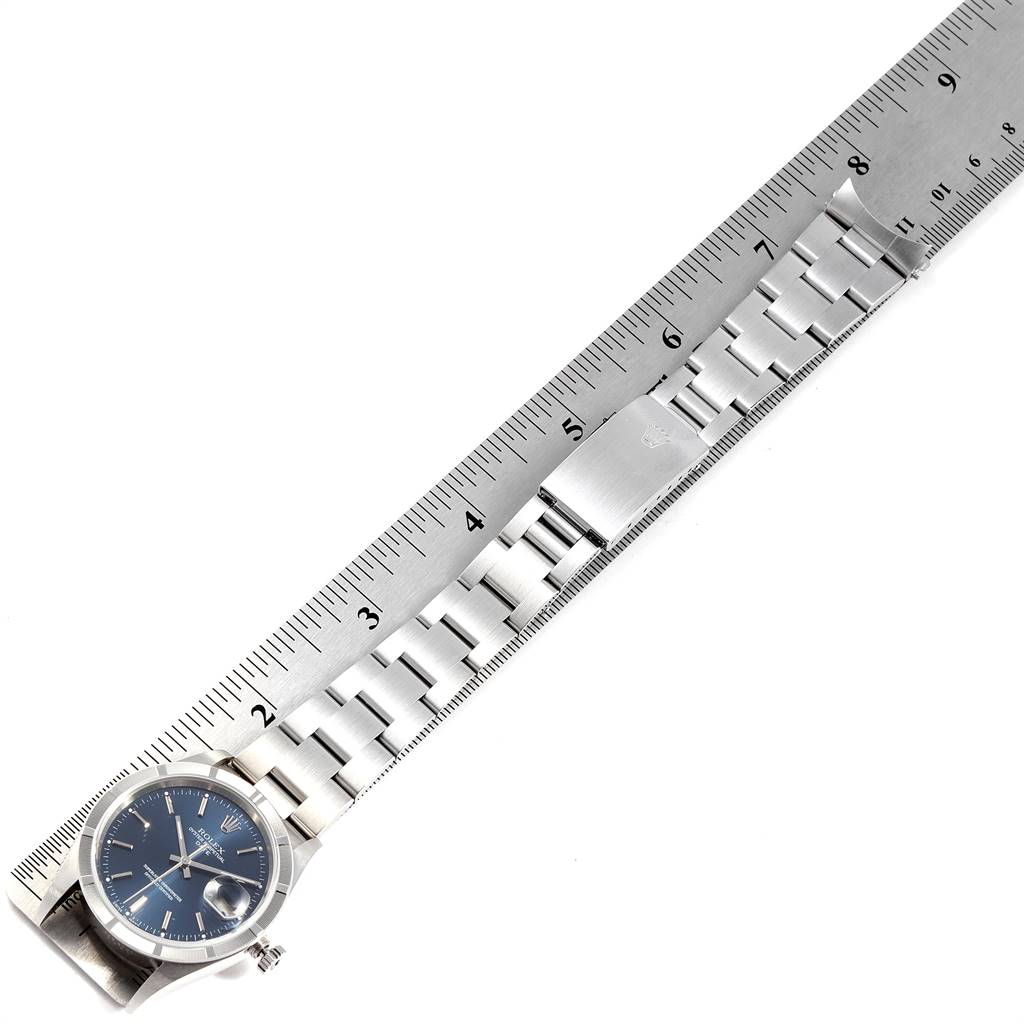 The Rolex Date 15210 Men's Stainless Steel Blue Dial 15210 Men's Stainless Steel Blue Dial watch is laid flat with the entire band and face shown, measured against a metallic ruler.