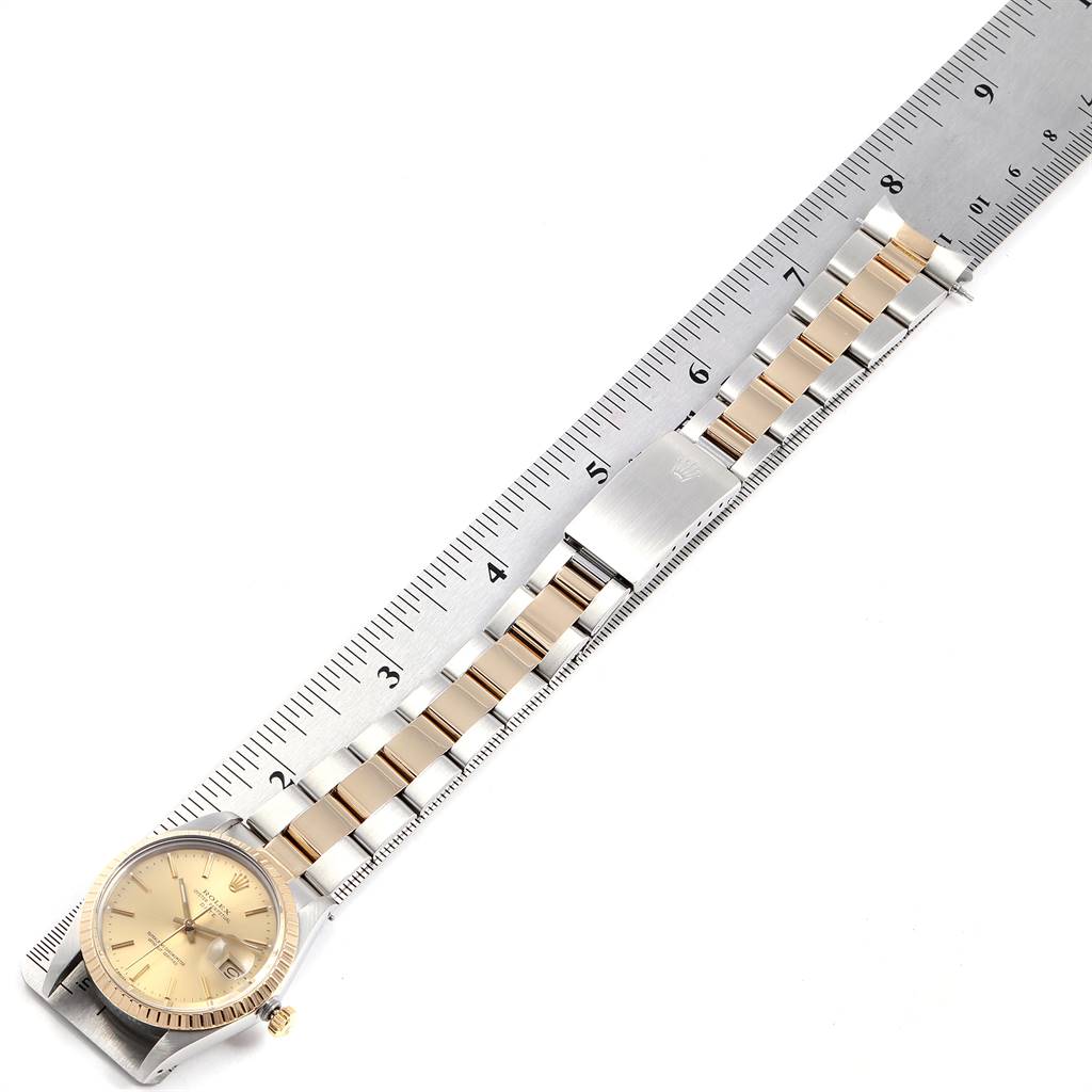 The Rolex Date 15053 Men's Steel and Gold (two tone) Champagne Dial 15053 Men's Steel and Gold (two tone) Champagne Dial model watch is displayed horizontally with the bracelet measured against a ruler.