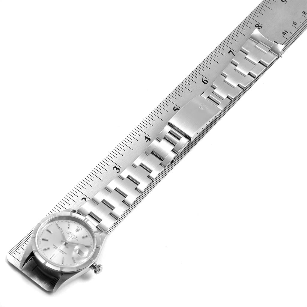 The image shows a Rolex Date 15210 Men's Stainless Steel Silver Dial 15210 Men's Stainless Steel Silver Dial model watch, positioned horizontally next to a ruler, displaying its face and bracelet.