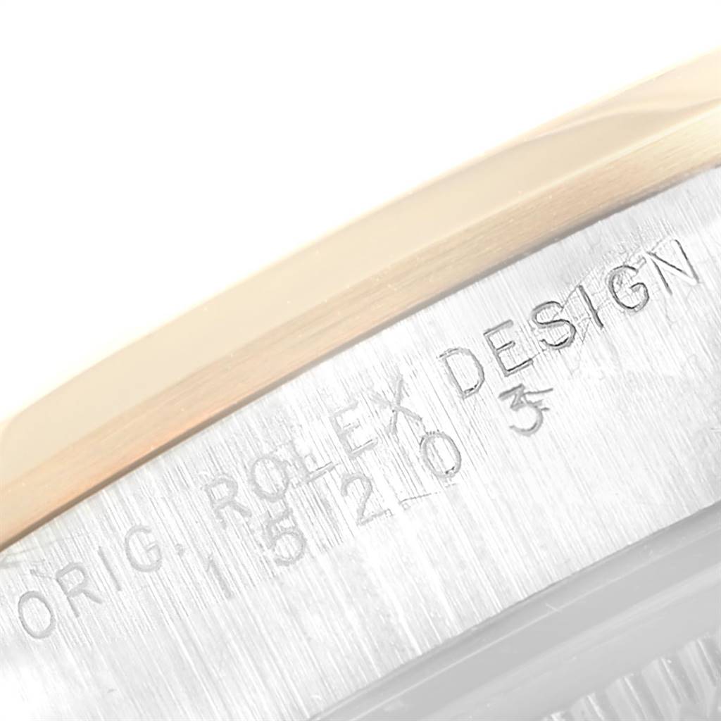 This image shows a close-up of the engraved bezel and part of the case of a Rolex Date 15203 Men's Steel and Gold (two tone) White Dial 15203 Men's Steel and Gold (two tone) White Dial model watch.