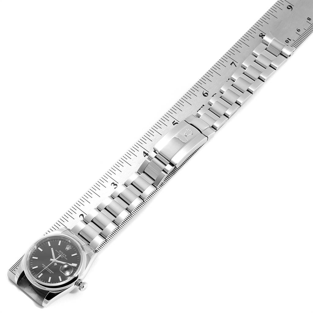 The Rolex Date 115200 Men's Stainless Steel Black Dial 115200 Men's Stainless Steel Black Dial model watch is shown from a top-down angle, highlighting its face, bracelet, and clasp.