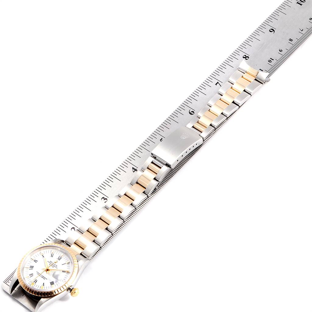 The image shows a Rolex Date 15223 Men's Steel and Gold (two tone) White Dial 15223 Men's Steel and Gold (two tone) White Dial model watch laid flat against a ruler, displaying its bracelet and clasp.
